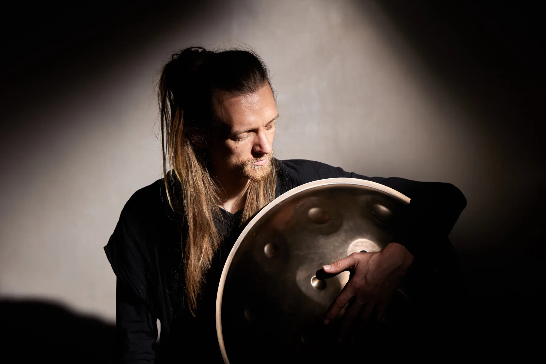 David Lesage holding one of his two Yishama handpans, bottom notes visible